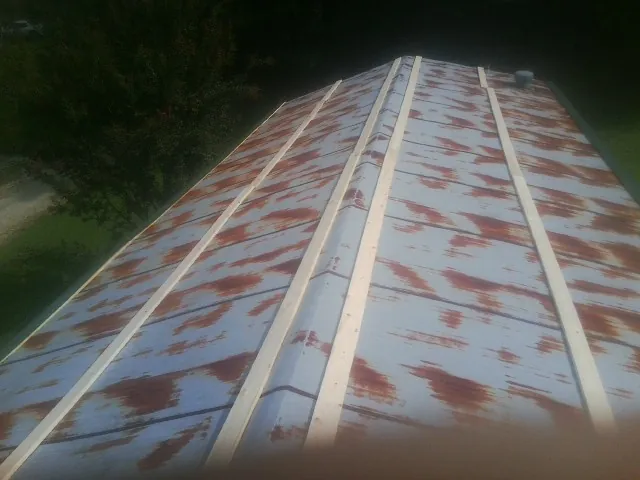 Rusted metal roof panels with new wood purlins before replacement — Storm Damage Roof Repair in North Bonneville by Roofing Brothers