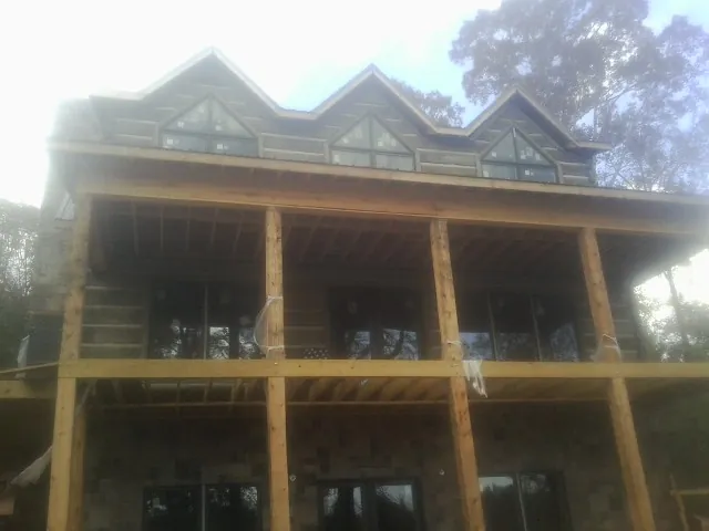 Dormers and porch framing on a large log home under construction — Roof Coating work by our crew in North Bonneville
