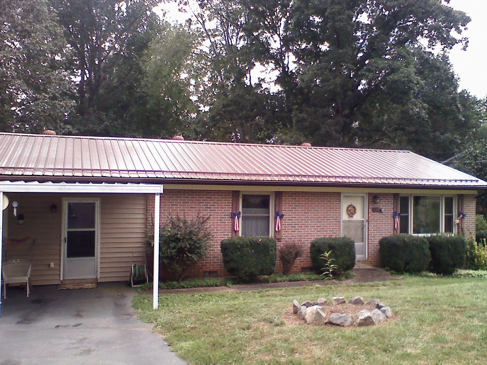 Bronze metal roof and carport on a brick ranch home — Roof Repair work by our crew in North Bonneville